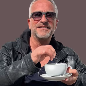 MaiP Jorgenson sitzt mit einer Tasse Kaffee und lächelt in die Kamera. Das Cover des Songs „Goldener Moment der Stille“ steht für Ruhe, Gelassenheit und die kleinen Augenblicke des Alltags.